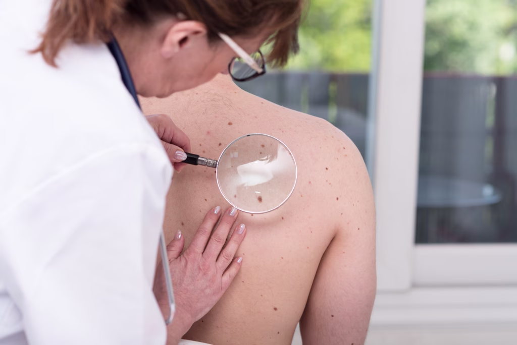 Dermatologist examining a patient's skin with a magnifier